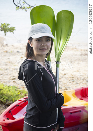 Cute woman enjoying kayaking Cute woman enjoying kayaking 129685937