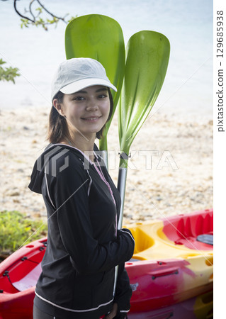 Cute woman enjoying kayaking Cute woman enjoying kayaking 129685938