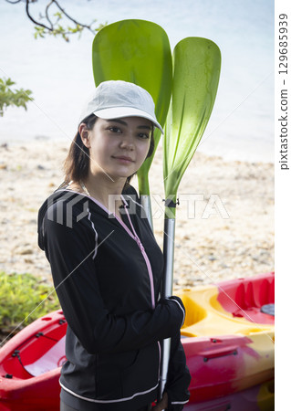 Cute woman enjoying kayaking Cute woman enjoying kayaking 129685939
