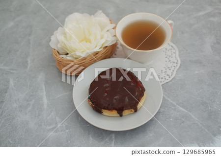 Chocolate Glazed Donut with Cup of Tea on Marble Table Chocolate Glazed Donut with Cup of Tea on Marble Table 129685965