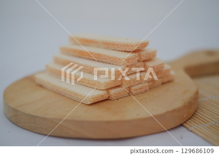 Stack of Crispy Wafer Biscuits on Wooden Board 129686109
