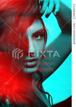Woman with long wavy hair sensual studio portrait in RGB color split effect style 129686231