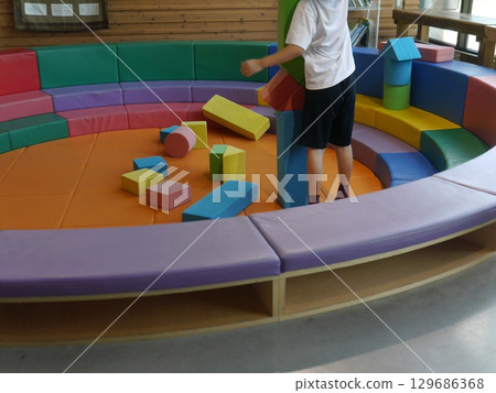 A child playing with building blocks in the kids' space (no face) A child playing with building blocks in the kids' space (no face) 129686368