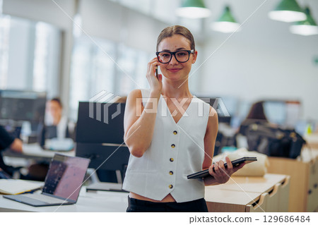 A Professional Woman Working in a Contemporary Office Environment, Engaging with Others 129686484