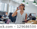 A dedicated businesswoman is actively engaged in her work at a modern and stylish office space 129686500