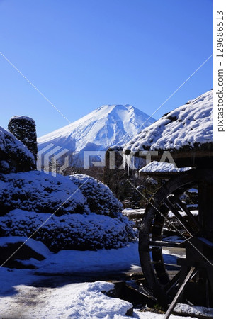 白雪皚皚的富士山和雪後村莊的水車。十二月風景：富士山 173 忍野八海 V3.2。 129686513