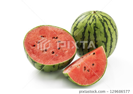 Whole and cut small watermelon on a white background Whole and cut small watermelon on a white background 129686577