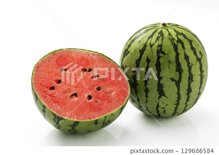 Whole and cut small watermelon on a white background 129686584