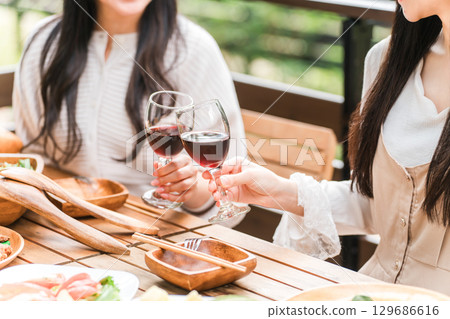 Young woman having a home party/glamping on a wooden deck 129686616