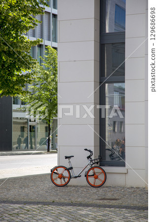 Berlin, Germany - July 01, 2018: Bicycle with red wheels on the sidewalk near the house 129686698