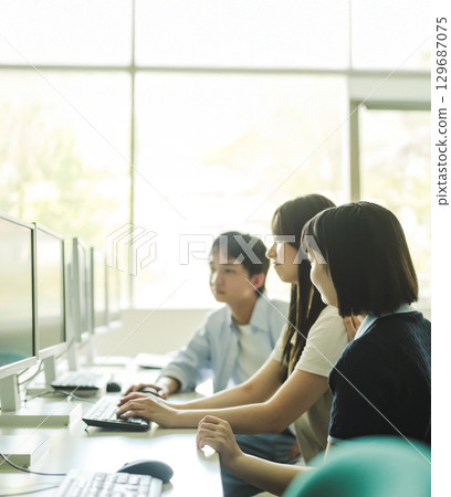 University students discussing in a computer classroom University students discussing in a computer classroom 129687075