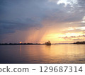 Mekong river landscape with rain fall and beautiful sunset reflected in still water in Laos 129687314