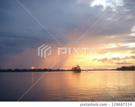 Mekong river landscape with rain fall and beautiful sunset reflected in still water in Laos Mekong river landscape with rain fall and beautiful sunset reflected in still water in Laos 129687314