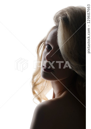 Beautiful woman with big wavy hair studio portrait in bright background 129687663