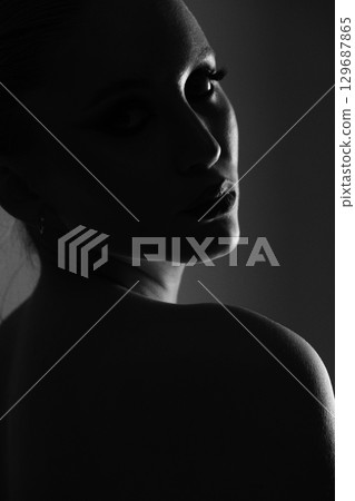 Beautiful woman dark silhouette studio portrait on gray background Beautiful woman dark silhouette studio portrait on gray background 129687865
