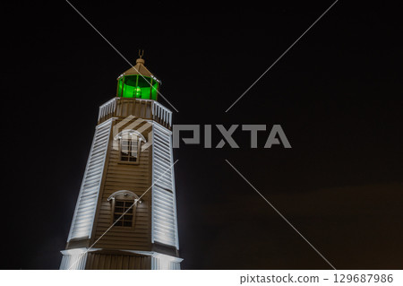 Illuminated lighthouse at night Illuminated lighthouse at night 129687986