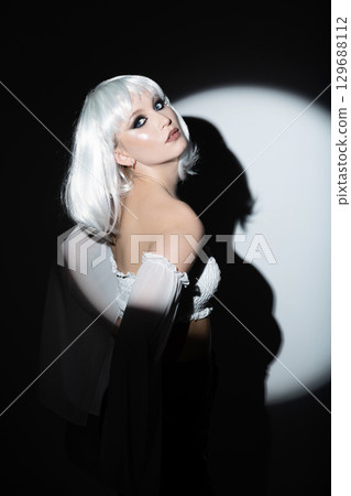 Beautiful woman with white wig portrait illuminated with bright round studio light 129688112