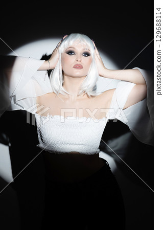 Beautiful woman with white wig portrait illuminated with bright round studio light 129688114