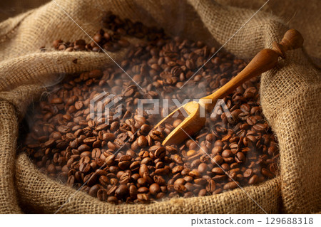 Fresh roasted coffee beans in burlap bag. 129688318