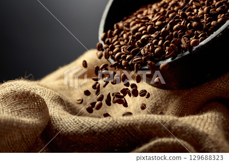 Freshly roasted coffee beans are poured into a bag. 129688323