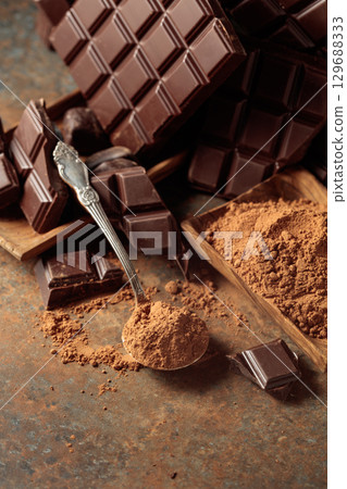 Broken bitter chocolate bar and cocoa powder. 129688333