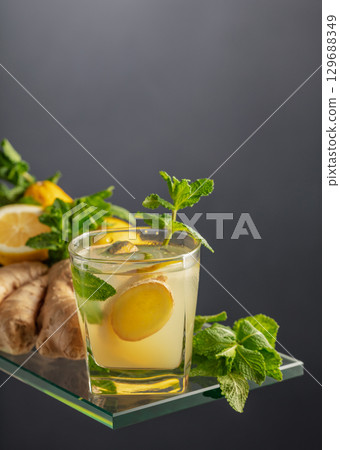 Refreshing summer cocktail with ice, ginger, lemon, and mint. 129688349