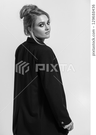 Beautiful woman with black suit studio portrait on white background 129688436