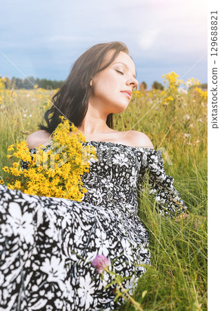 Woman Enjoying Nature in Flower Field 129688821