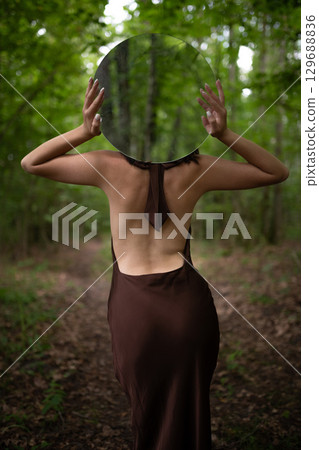 Mystic Woman with Round Mirror Portrait in Forest 129688836