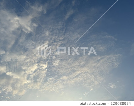 The sky with clouds illuminated by the setting sun 129688954