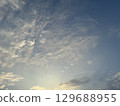 The sky with clouds illuminated by the setting sun 129688955