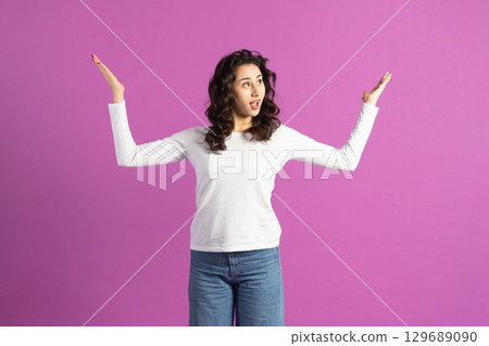 Portrait of young woman with raised hands Portrait of young woman with raised hands 129689090