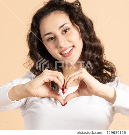 Beautiful woman showing fingers heart sign Beautiful woman showing fingers heart sign 129689156