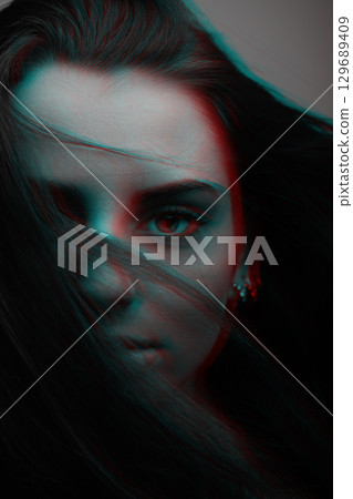 Beautiful woman with blue eyes cover her face with hair in RGB color effect style 129689409