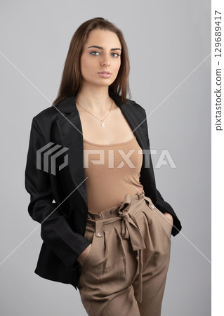 Business woman with black jacket and beige trousers portrait Business woman with black jacket and beige trousers portrait 129689417