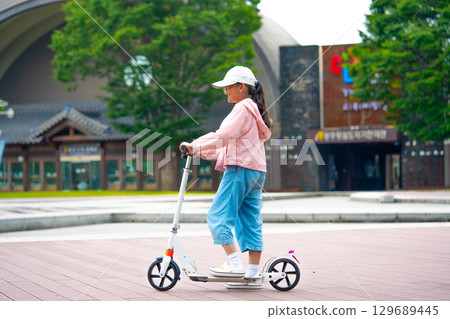 Asian girl is going to ride a scooter. Copy space 129689445