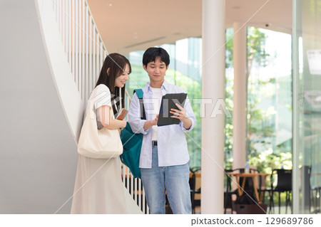 Male and female university students talking inside the school building 129689786