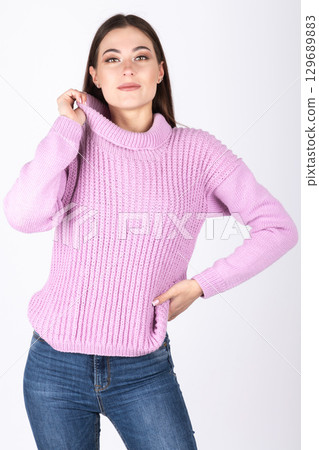 Beautiful woman with pink sweater and blue jeans portrait 129689883