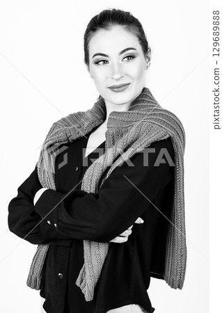 Studio portrait of beautiful woman with purple sweater on her shoulders 129689888