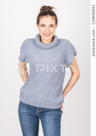 Beautiful woman with blue sweater without sleeves and blue jeans Beautiful woman with blue sweater without sleeves and blue jeans 129689891