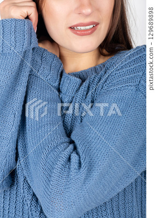 Beautiful woman studio portrait wearing blue sweater Beautiful woman studio portrait wearing blue sweater 129689898