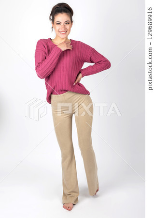 Woman portrait with purple sweater and beige trousers 129689916