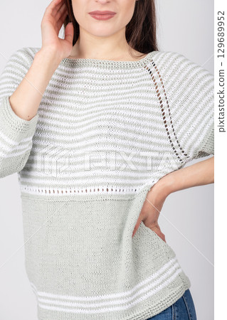 Beautiful woman studio portrait wearing bright sweater and blue jeans 129689952