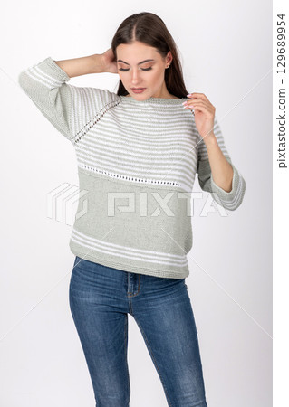 Beautiful woman studio portrait wearing bright sweater and blue jeans 129689954