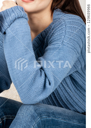 Beautiful woman studio portrait wearing blue sweater and jeans Beautiful woman studio portrait wearing blue sweater and jeans 129689966