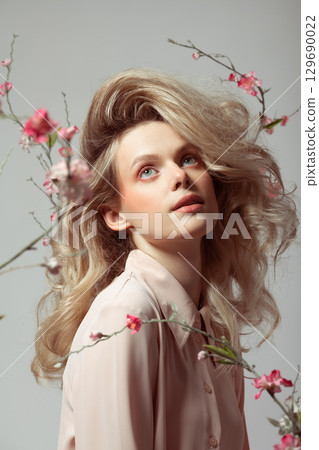 Beautiful woman with big wavy hair and flowers studio portrait Beautiful woman with big wavy hair and flowers studio portrait 129690022