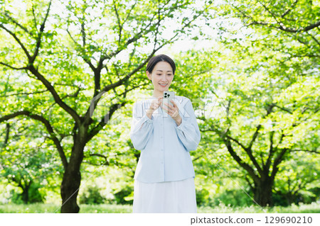 Young woman operating a smartphone - lifestyle image Young woman operating a smartphone - lifestyle image 129690210