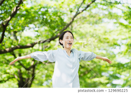 年輕女子在樹下伸展身體 生活方式圖像 129690225