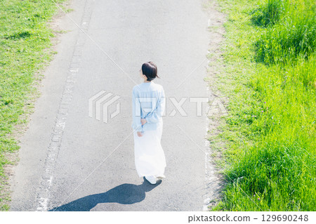 Young woman walking on a promenade Lifestyle image 129690248