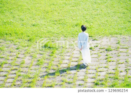 Young woman walking through the grassland Lifestyle image 129690254